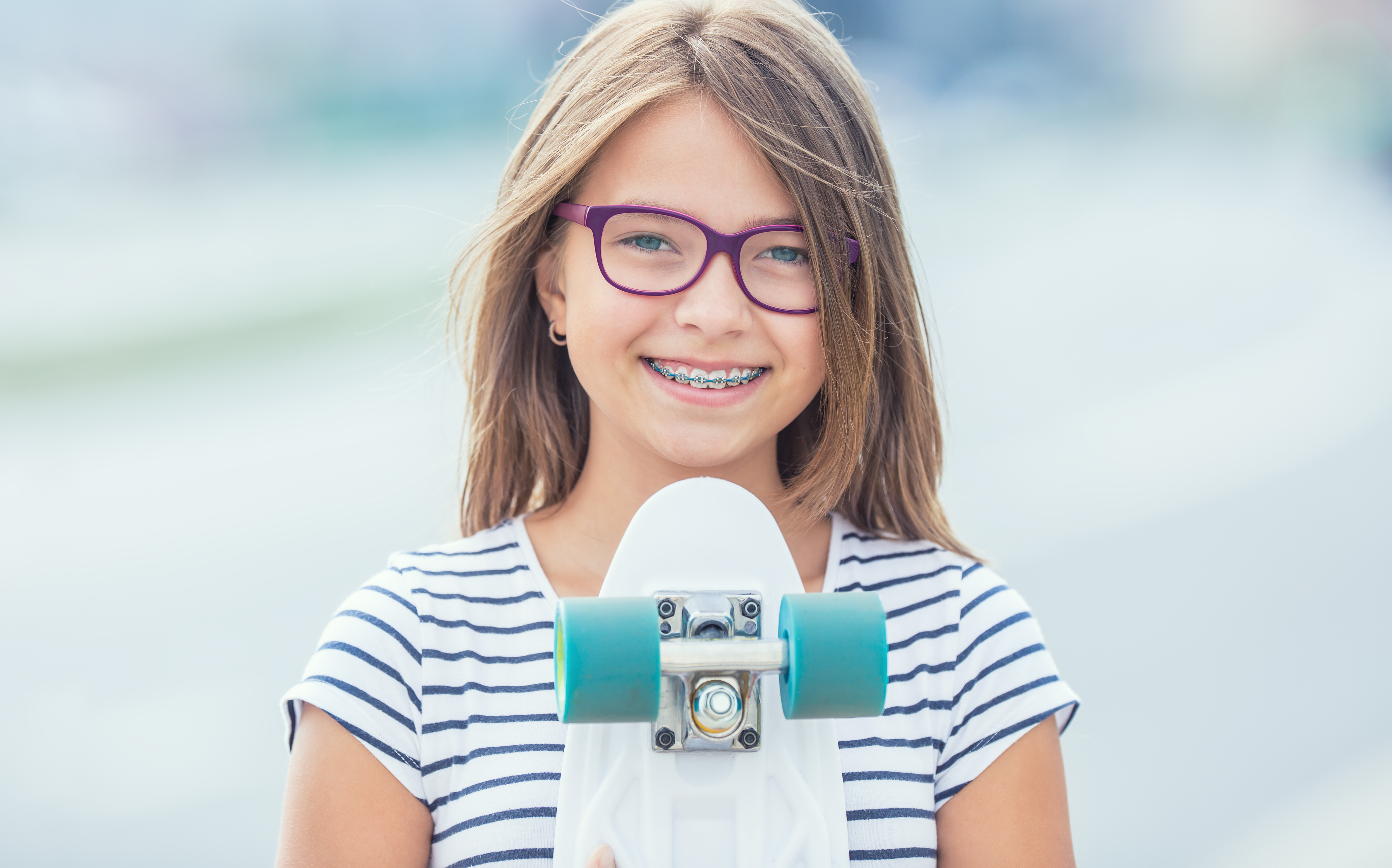 Portrait of happy smiling girl with dental braces and glasses.